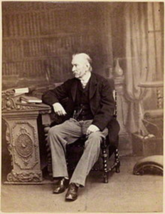 Photographic portrait of Samuel Hunter Christie seated at his desk