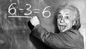 Famous photo of Albert Einstein writing an equation on the blackboard and sticking out his tongue