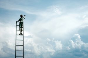 Child on a ladder in the clouds of sky